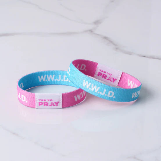 Two wristbands, one pink and one blue, with 'WWJD' and 'Tap to Pray' text on a white background.