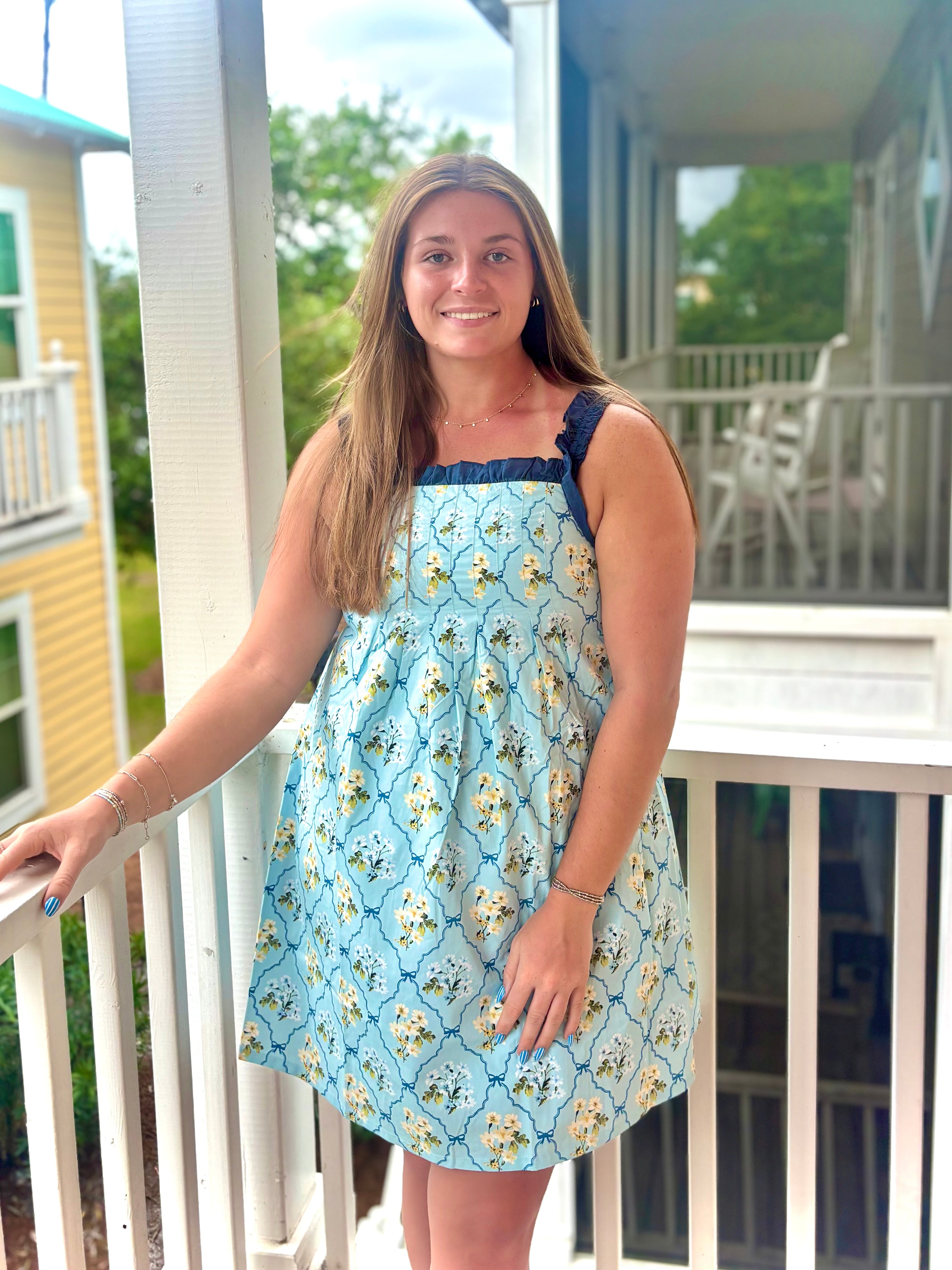 Woman wearing a blue floral dress on a porch