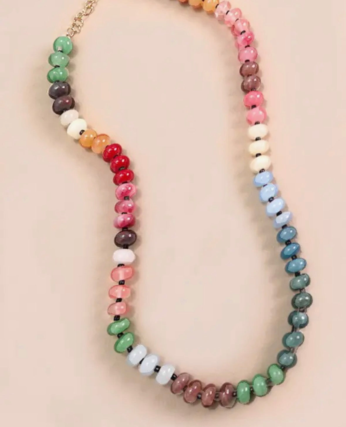 Multicolored beaded necklace on a beige background