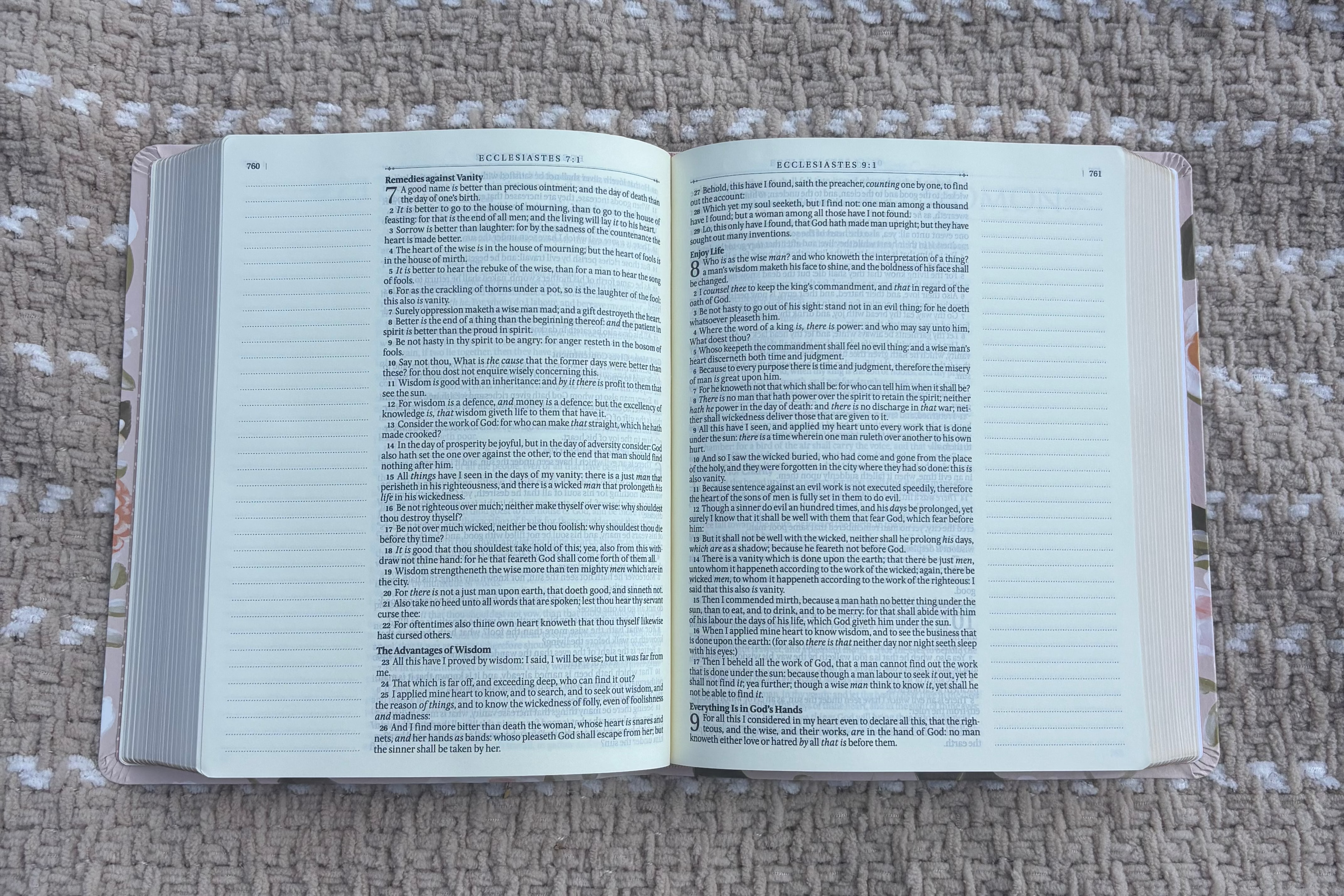 Open Bible with text on the pages laying on a beige blanket outdoors