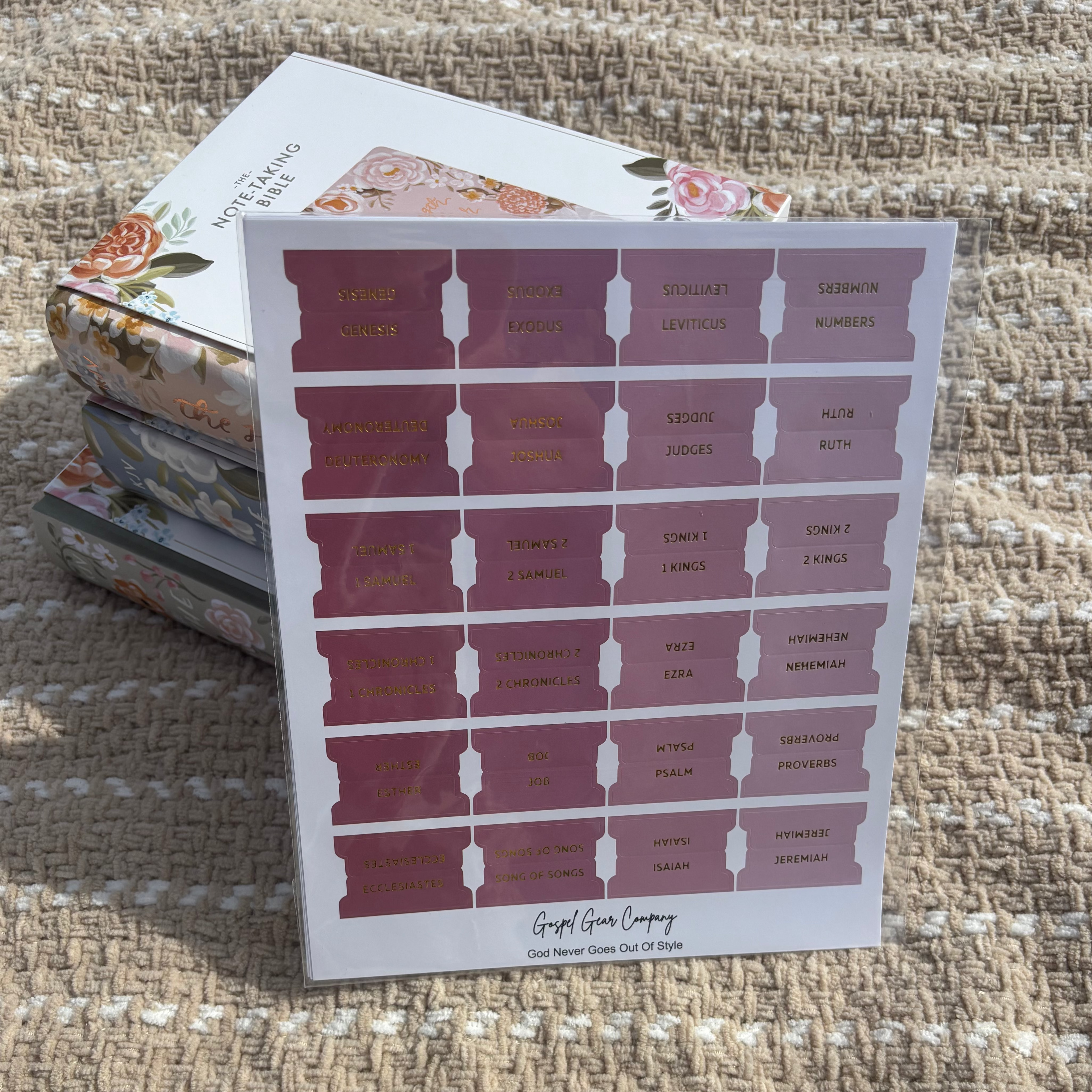 Dusty Rose Bible tabs propped against floral Bibles laying on a beige blanket outside