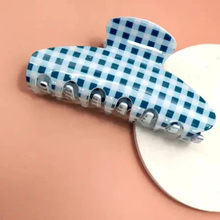 Blue and white checkered hair clip on a peach background