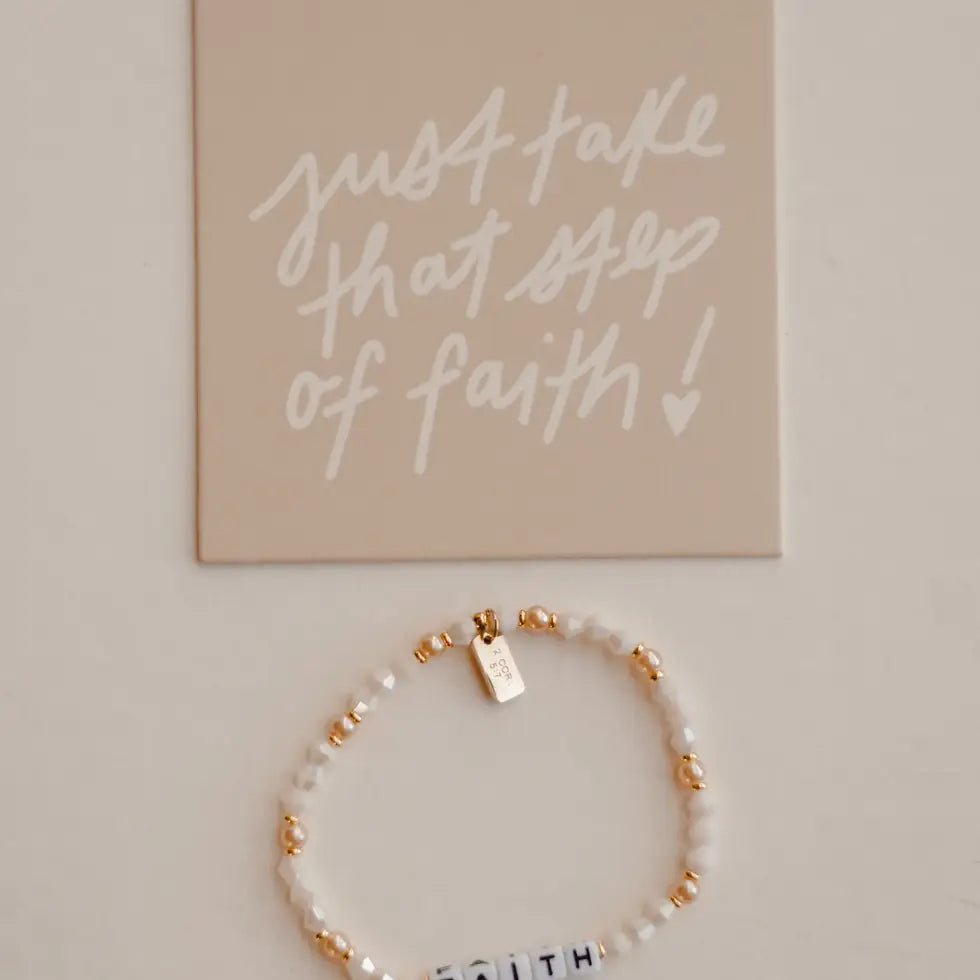 Bracelet with letter beads spelling 'FAITH' on a neutral background with motivational quote