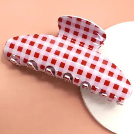 Red and white checkered hair clip on a peach background